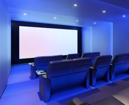 A modern dedicated home theater with ambient lighting and a large 4K screen